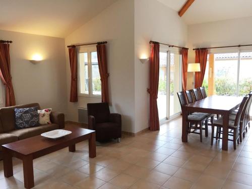 a living room with a couch and a table at Holiday Home in Sampzon near Ardeche River in Sampzon