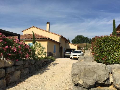 a house with two cars parked in a driveway at Holiday Home in Sampzon near Ardeche River in Sampzon