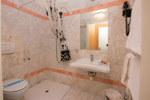 een badkamer met een wastafel, een toilet en een spiegel bij Hotel Campagna in Cannobio