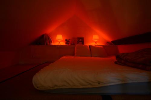 Posto letto in camera con illuminazione rossa di Gîte de Bugeron a Vicq-Exemplet