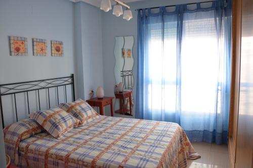 a bedroom with a bed and a window at El apartamento de Mamá - Cabo Roig in Playas de Orihuela