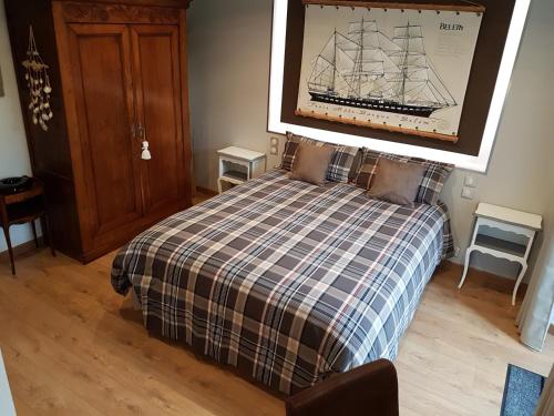 a bedroom with a bed with a checkered blanket at Résidence CoatArmor in Tonquédec