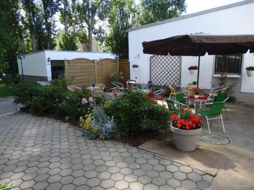 a patio with a table and chairs and an umbrella at Zur Saale in Weißenfels