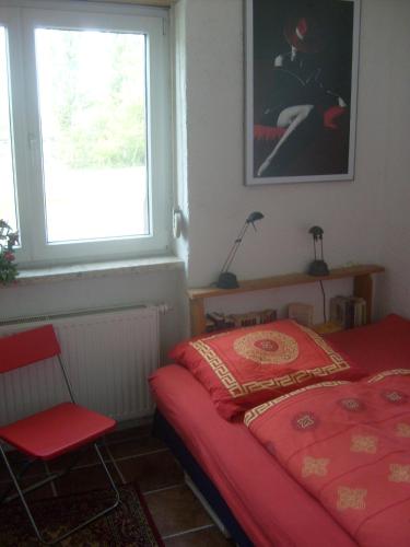 1 dormitorio con cama roja y ventana en Theater am Eck, en Freiburg im Breisgau