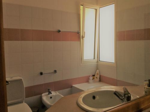Madalena do MarにあるApartamento Vai Vemのバスルーム(洗面台、トイレ付)、窓が備わります。