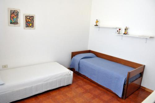 a room with two beds and shelves on the wall at Due Passi Dalla Spiaggia in Lido Marini