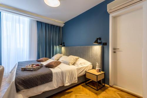 a bedroom with a large bed and a blue wall at Central Rooms Split in Split