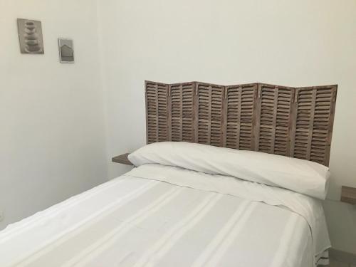 バレンシアにあるReinaのベッド(白いシーツ、木製ヘッドボード付)