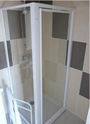 d'une porte de douche en verre avec une chaise dans la salle de bains. dans l'établissement La Ferme aux Biches, à Commelle-Vernay