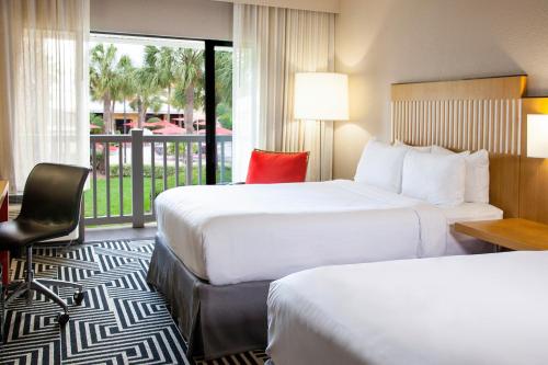 a hotel room with two beds and a balcony at Wyndham Orlando Resort International Drive in Orlando