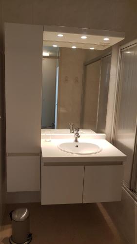Un baño con un lavabo blanco y un espejo. en Le 1003, en Nieuwpoort