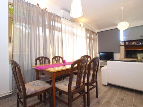 a dining room with a wooden table and chairs at Apartments Mario 1401 in Fažana