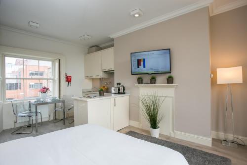 una camera con letto e una cucina con TV a parete di Hatch Street St Stephen's Green Apartments a Dublino