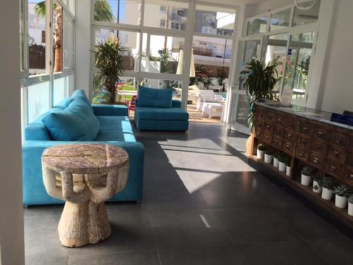 a living room with a blue couch and a table at Apartamentos Es Cantó in Playa d'en Bossa