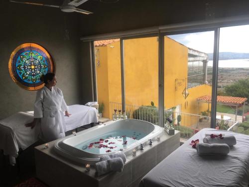 a woman standing in a room with a bath tub at View Hotel Boutique in San Miguel de Allende
