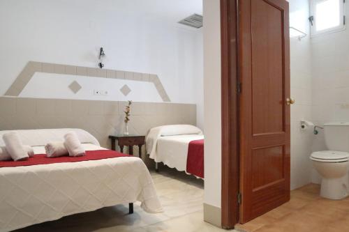 pokój hotelowy z 2 łóżkami i toaletą w obiekcie Hostal Victoria w mieście La Carlota