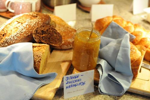 a table with bread and a jar of mustard and buns at Hotel Talhof Garni&more in Wängle bei Reutte in Reutte