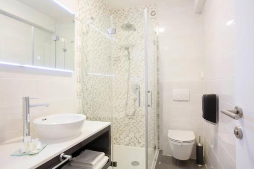 a bathroom with a shower and a sink and a toilet at Boutique Hotel Intermezzo - Pag centre in Pag