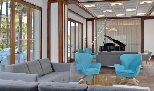 a living room with a couch and chairs and a piano at Sol Torremolinos - Don Pablo in Torremolinos