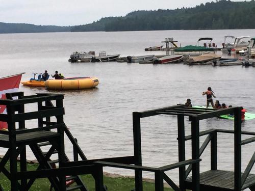 a group of people on a body of water with boats at Little Hawk Resort & Marina in Algonquin Highlands