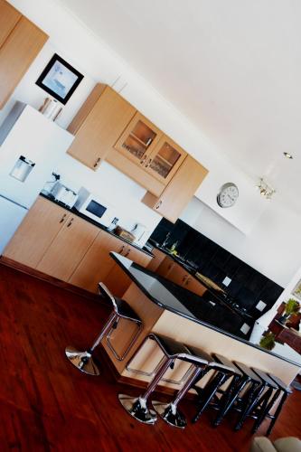 una cocina con una fila de taburetes en Abalone Self-Catering, en Lambertʼs Bay