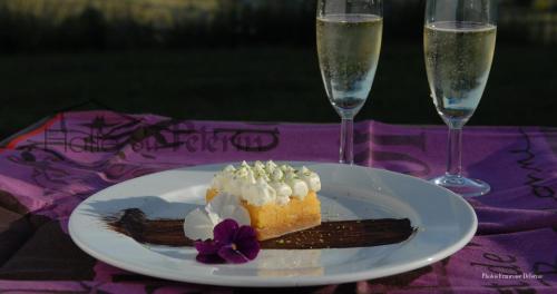 un morceau de gâteau sur une assiette avec deux verres de champagne dans l'établissement La Halte du Pèlerin Chambres d'hôtes, à Chérier