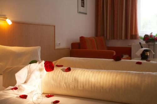 a hotel room with two beds with roses on them at Hotel Talhof Garni&more in Wängle bei Reutte in Reutte