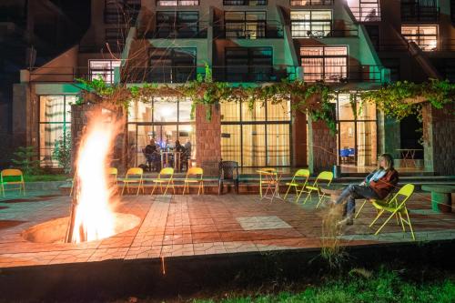 a man sitting in a chair next to a fire pit at Panoramic View Hotel in Lalībela