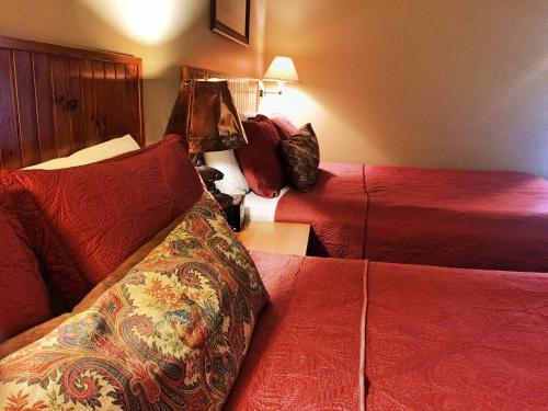 a hotel room with two beds with red sheets at Hungry Trout Resort in Wilmington