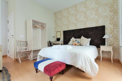 a large white bed with a large headboard in a bedroom at Hostly Acetres 1A loft in city center, comunal terrace, fibre,parking optional in Seville