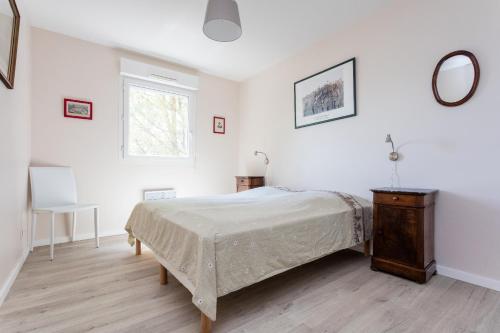 une chambre avec un lit, une table et une fenêtre dans l'établissement Les Jardins de Nazareth, à Montpellier