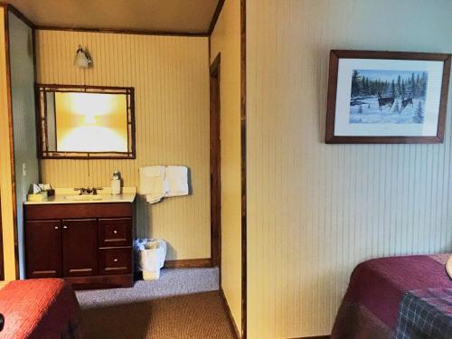 a hotel room with a bathroom with a sink and a mirror at Hungry Trout Resort in Wilmington