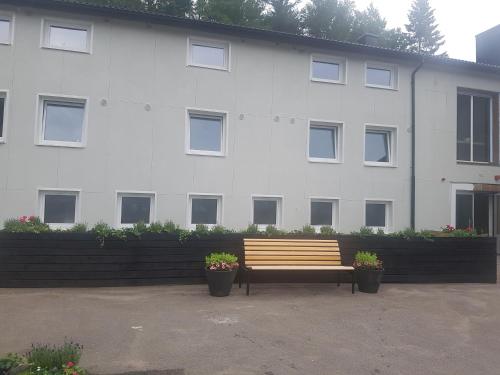 a wooden bench in front of a white building at Alkoven Logi in Ullared