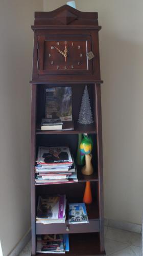 a book shelf with a clock on top of it at Urdesa Suites Hotel in Guayaquil