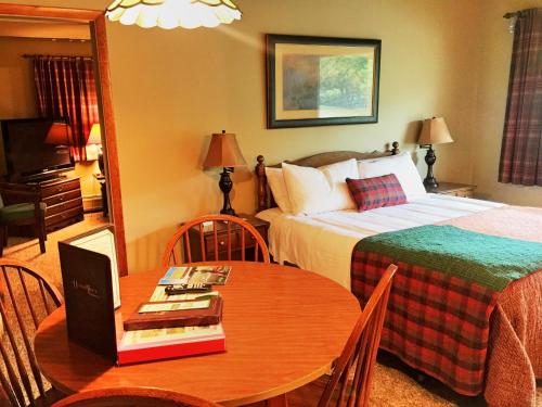 a hotel room with a bed and a table with a laptop at Hungry Trout Resort in Wilmington