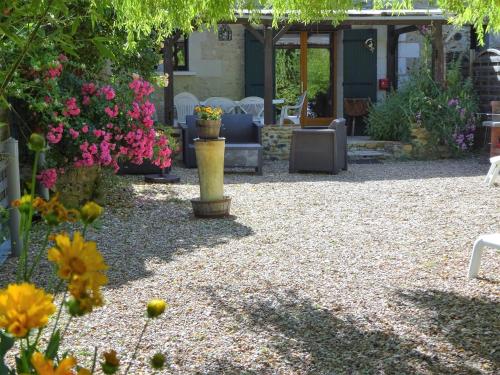 a garden with flowers and tables and chairs at Les chaumières du Chêne in Pouillé