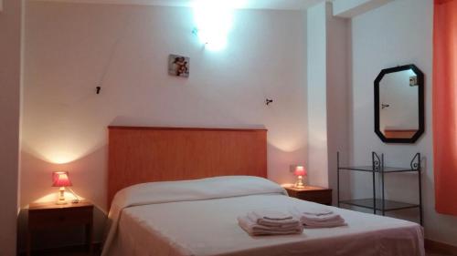 a bedroom with a bed with two lamps and a mirror at Casa Lucia Campagna Relax in Dorgali