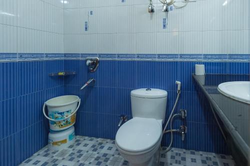 a blue and white bathroom with a toilet and a sink at The Thistle Lodge in Shimla