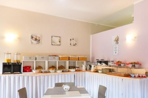a kitchen with a counter with a table and chairs at Hotel Alpi Resort in Turin
