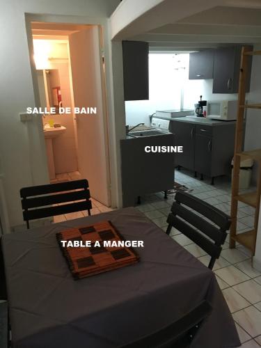 a kitchen with a table in the middle of a room at à pied dans l eau écolo 97434 in L'Ermitage-Les-Bains