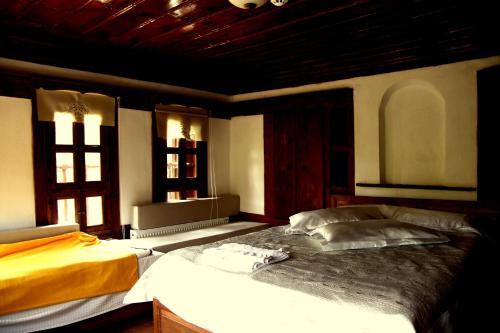a bedroom with two beds and two windows at Çamlıca Konak Çarsı in Safranbolu