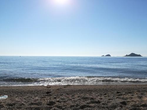 une plage avec l'océan et les îles au loin dans l'établissement Casa Vacanze Bellavista, à Santa Maria Navarrese