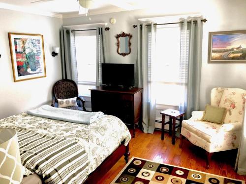 a bedroom with a bed and a chair at Bourne Bed and Breakfast in Ogunquit
