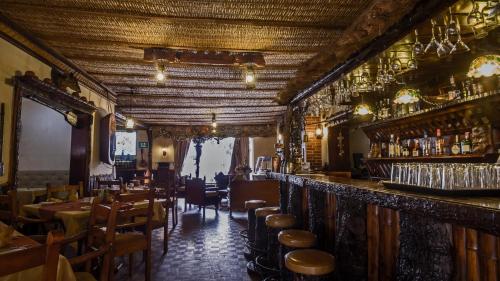 a restaurant with a bar with tables and chairs at Hosteria Rumipamba De Las Rosas in San Miguel de Salcedo