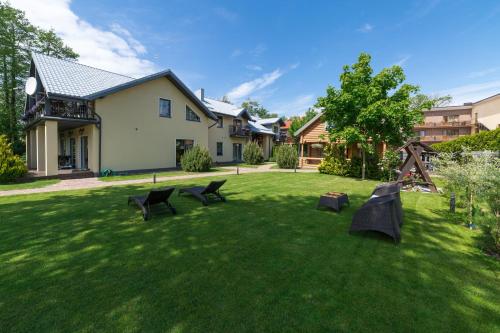 a yard with two chairs and a house at Rasos Vila in Palanga