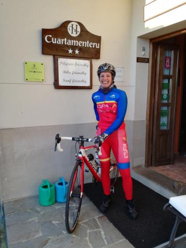 a woman is standing next to a bike at Hotel Rural Cuartamenteru in Llanes