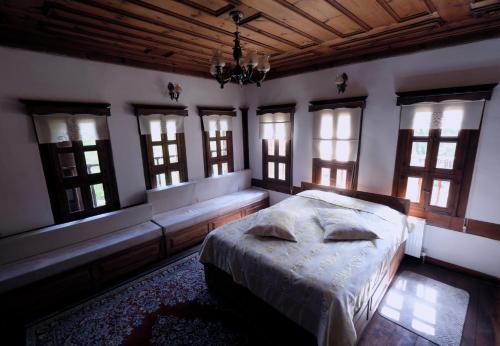a bedroom with a bed and windows and a chandelier at Çamlıca Konak Çarsı in Safranbolu