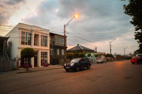 a car driving down a street in a town at White Hotel Guesthouse in Zugdidi