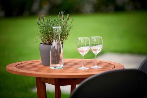 a table with two wine glasses and a potted plant at Villa Emma in Ostseebad Sellin