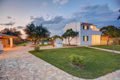 uma casa com um relvado em frente em Skales Villas em Almiros Beach